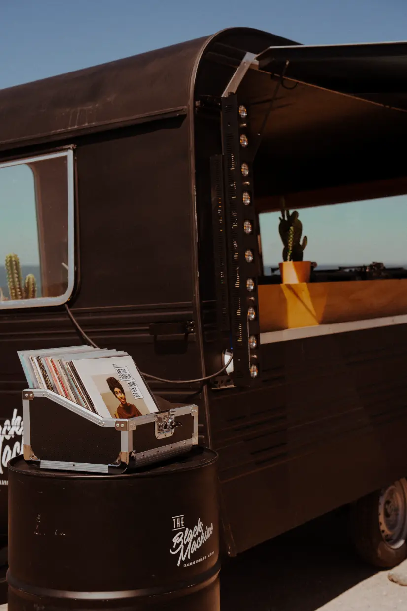 Mallette de vinyles vintage devant la caravane DJ The Black Machine – animation musicale mobile et stylée